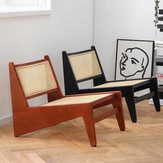 two wooden chairs sitting next to each other on top of a hard wood floor in front of a window