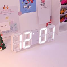 an alarm clock sitting on top of a table next to a christmas tree and other items