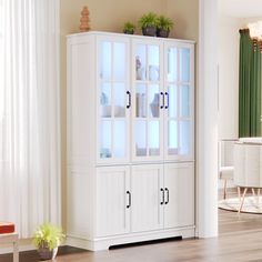 a white china cabinet with glass doors in a living room