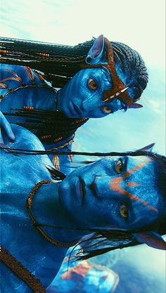 two people dressed in blue are standing next to each other with their faces painted like avatars