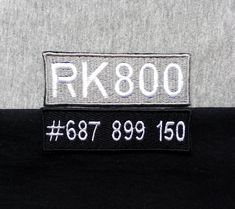 the back of a black and grey shirt with white letters that read rk800