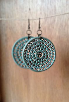 two circular earrings hanging from a clothes line