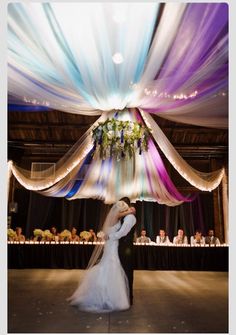 the bride and groom are dancing together in front of an audience at their wedding reception