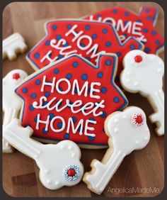 some decorated cookies are on a wooden table with the words home sweet home written in red, white and blue