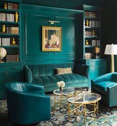 a living room filled with furniture and bookshelves covered in green paint on the walls