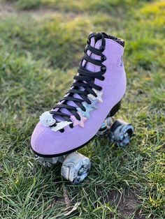 a purple roller skate with black laces on the top and bottom, sitting in grass