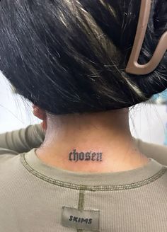 the back of a woman's neck with her name tattooed on it