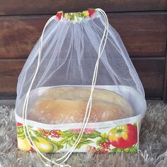 a bag with a sandwich in it sitting on top of a rug next to a wooden wall