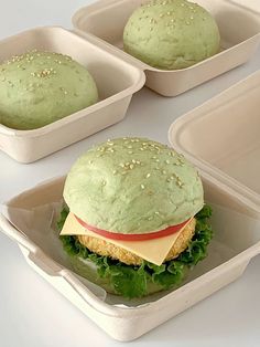 three plastic containers with sandwiches in them on a table