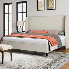 a large bed sitting on top of a wooden floor next to a chair and window