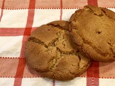 two cookies sitting on top of a red and white checkered table cloth