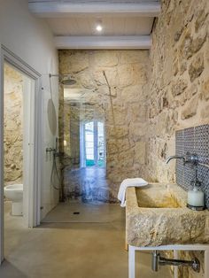 a bathroom with stone walls and flooring