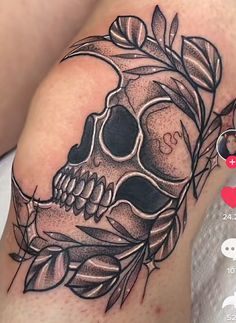 a tattoo with a skull and leaves on it