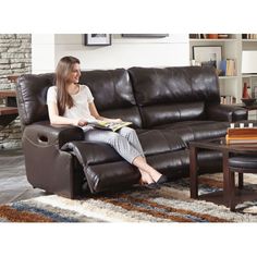 a woman sitting on top of a brown couch