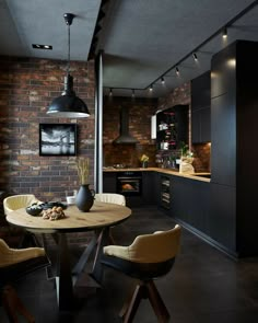 a dining room table and chairs in front of a brick wall with lights hanging from the ceiling