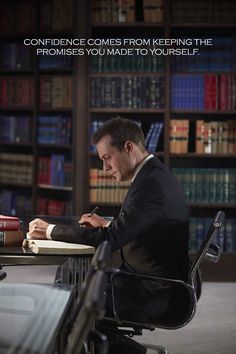 a man sitting at a desk in front of a book shelf