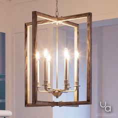 a chandelier hanging from the ceiling in a room with white walls and blue cabinets