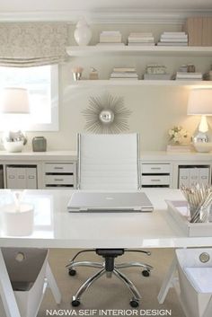 a white desk with two chairs and a laptop computer on it in a home office