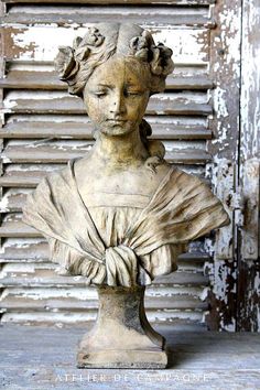 a statue of a woman wearing a headdress is shown in front of an old door