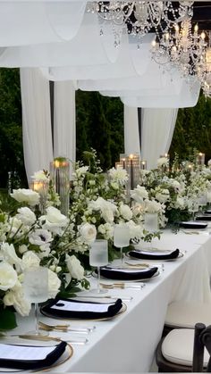 a long table is set with white flowers and candles