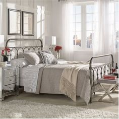 a bedroom with a metal bed frame and white walls