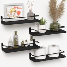 two black shelves holding toilet paper and other items