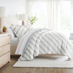 a bed with white and blue comforters in a bedroom