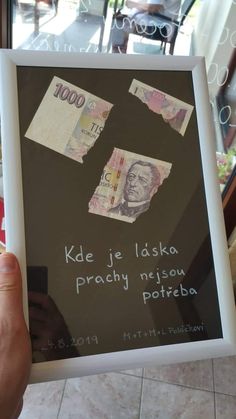 a person holding up a framed poster with money on it's back and the words, kore je idisko pracity neisu patebra