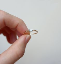 a person holding a tiny ring in their hand