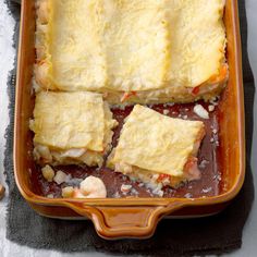 four square pieces of food sitting in a casserole dish on top of a towel