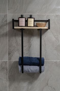 a shelf with two bottles on it next to a towel rack in a tiled bathroom