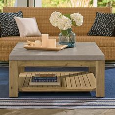 a living room with a couch, coffee table and flowers in vases on it