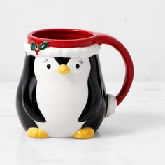 a penguin mug with a santa hat on its head