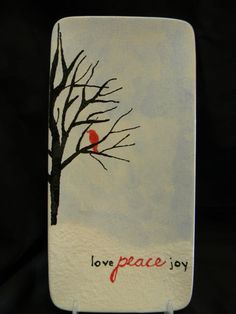 there is a red bird sitting on a tree with the word love peace joy written below it