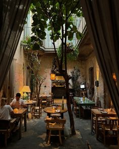 a restaurant with lots of tables and chairs in the middle of an indoor courtyard area