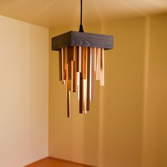 a wooden chandelier hanging from the ceiling in a room with yellow walls and wood flooring