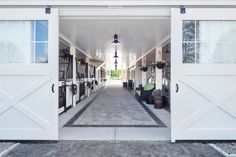 an open white garage door leading to another room with potted plants on either side