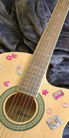 a close up of an acoustic guitar with stickers on it's strings and neck