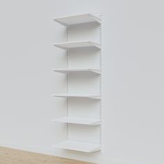 an empty white shelf against a wall