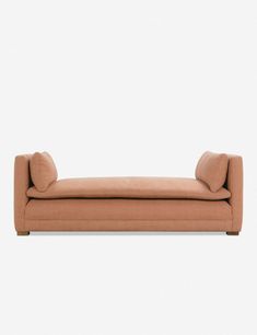 an orange couch sitting on top of a white wall