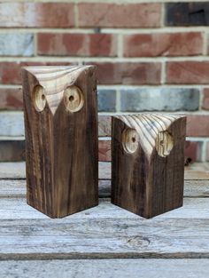 two wooden blocks with faces carved into them