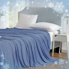 a bed covered in a blue blanket with snowflakes on it