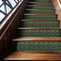 a set of stairs with green tiles on the bottom and bottom, along with wooden handrails