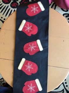 the table has three stockings with snowflakes on them, and one is red