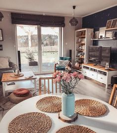 a living room filled with furniture and a table covered in placemats next to a window