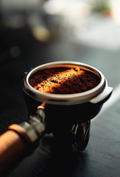 a cup of coffee sitting on top of a table next to an orange object in the foreground