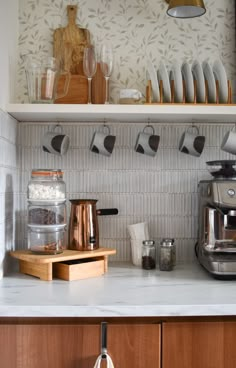 the kitchen counter is cluttered with dishes, cups and utensils on it