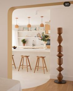 an open kitchen and living room with stools