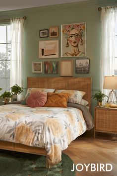 a bed sitting in a bedroom next to a window with pictures on the wall above it