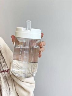 a woman holding a water bottle with her hair in it